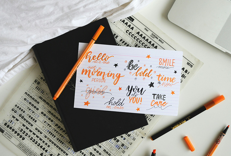 Illustration of a designer drawing on a sketchbook next to the title “Unique Hand-Drawn Fonts That Add Personality to Your Design”, used as a blog cover about hand-drawn typography.